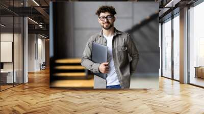 Happy manager ready for work from home on his laptop. Wall mural